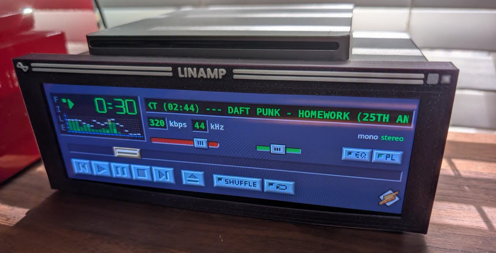 A hand-built physical Winamp music player glowing on a workbench