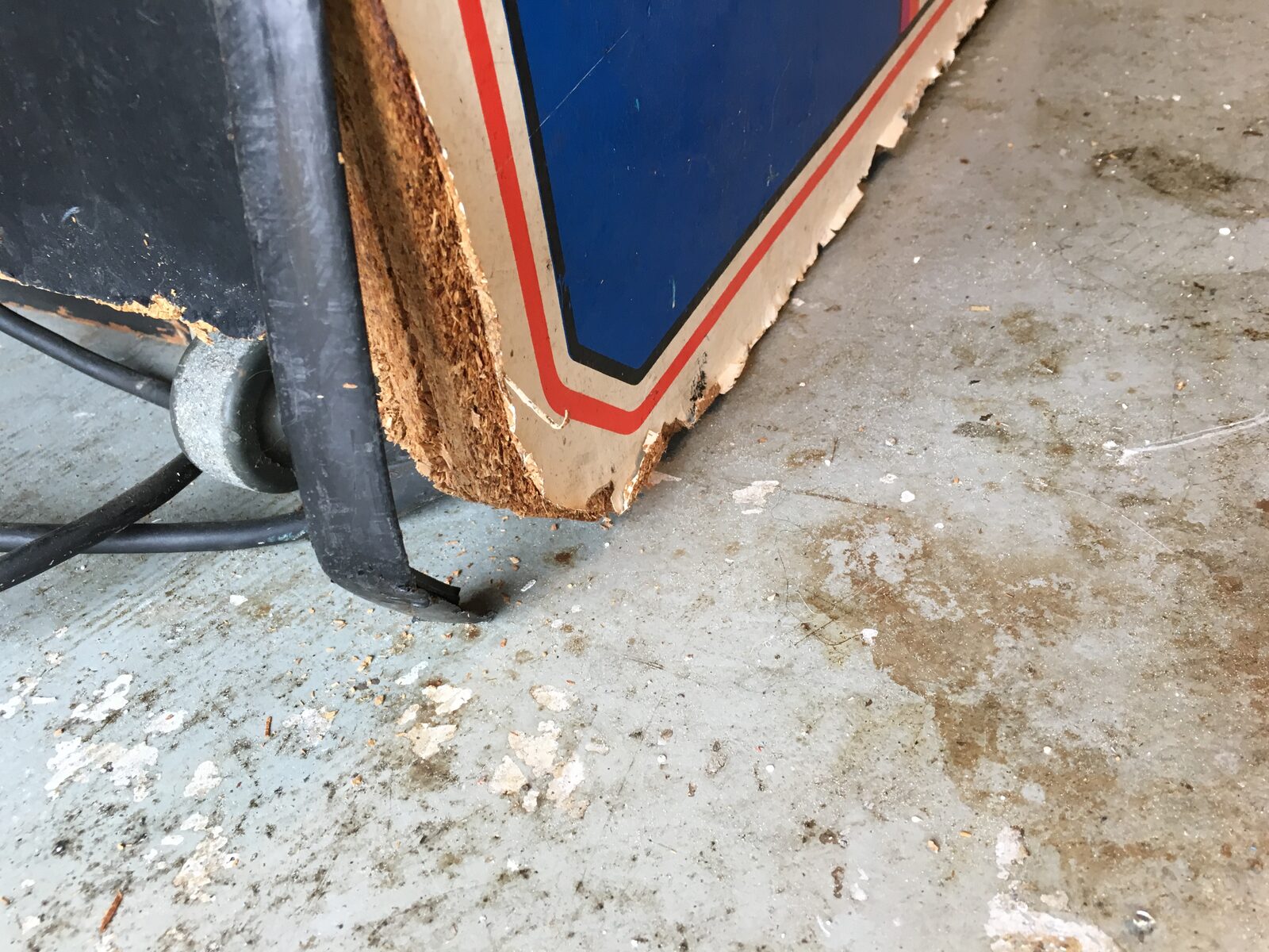 Water-swollen, crumbling particleboard at the base of a cabinet panel