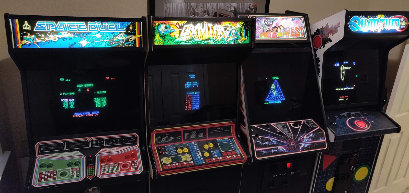 Four restored Atari vector arcade cabinets running side by side, Space Duel, Gravitar, Tempest, and Quantum